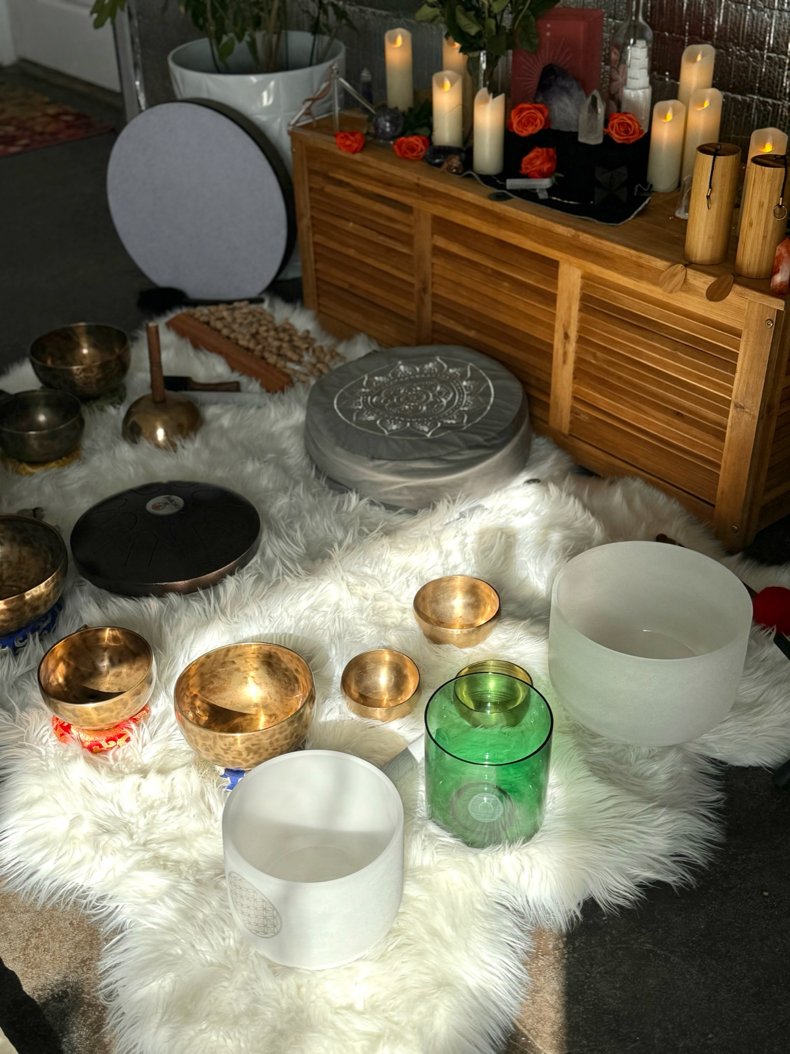 Multiple bowls used for sound meditation on a white furry carpet.
